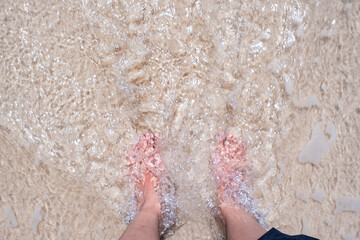 インドネシアの海で足だけ入っている