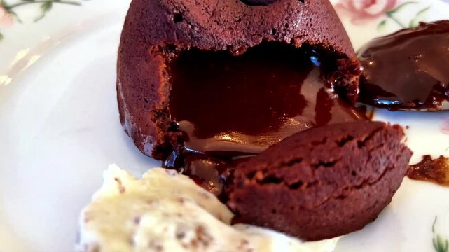 Melted chocolate flowing after petit gateau is cut and camera zooming