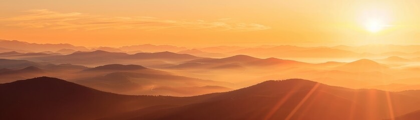 Breathtaking sunrise over misty mountain range, showcasing vibrant orange hues and serene natural beauty, ideal for nature and travel imagery.