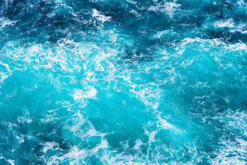 Waves as background. Huge ocean waves near the coast. Nature. Background and wallpaper in nature. Water surface as texture. Blue water and sea foam.