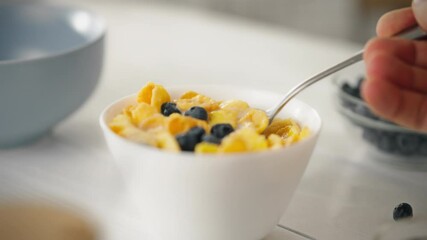 Vegetarian breakfast close-up cornflakes in milk in a bowl. A steel spoon scoops up flakes. Proper nutrition for staying in shape. Healthy lifestyle