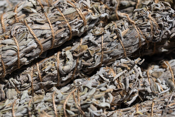 Bundles of sage neatly arranged in a basket, ready for smudging or use as spices. The image highlights the natural and aromatic qualities of sage in a rustic setting.
