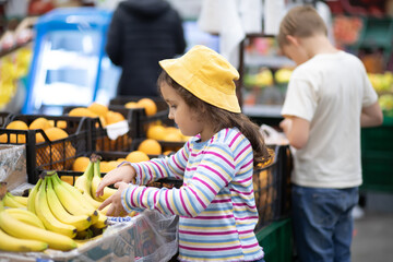 Kids little cute girl and teenager boy shopping for fresh organic fruits bananas and vegetables in...