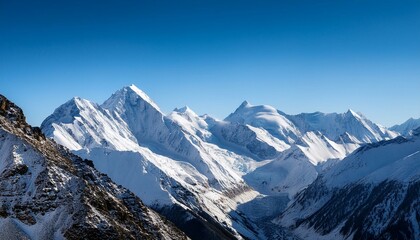 Fototapeta premium A mountain range with snow-covered peaks and a clear blue sky
