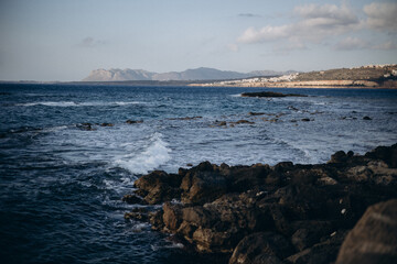 beautiful view on the mountains and waves crashing on rocks