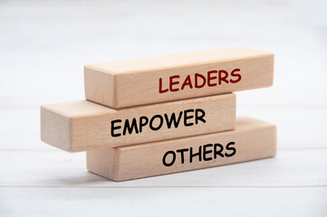 Leaders empower others text on wooden blocks. Leaderships concept