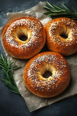 Freshly baked bagels with assorted toppings and herbs on a rustic background