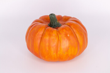 A vividly orange pumpkin with deep grooves, displayed against a clean white background, perfect for autumn decorations and seasonal festivities