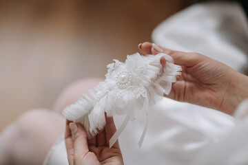 A woman is holding a white wedding band with a pearl on it