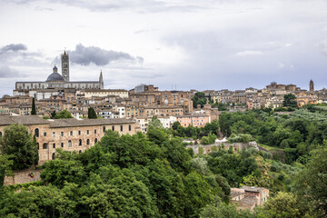Fototapeta premium Ogólna panorama Sienny w letnie pochmurne popołudnie z widokiem katedry na pierwszym planie
