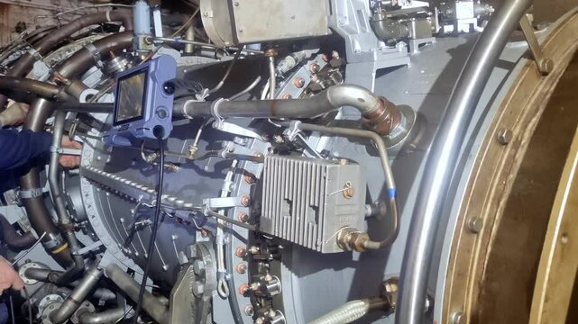 Electrical equipment specialist inspects turbine cables and connections using infrared cameras. This analysis detects overheating, preventing electrical malfunctions and potential fires.