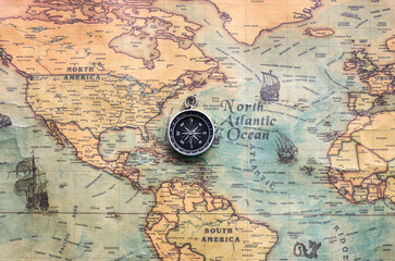 Classic round compass on background of old vintage map