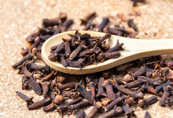 Dry clove spice on a wooden spoon close up. Spicy spice of cloves.  Dry spice cloves.