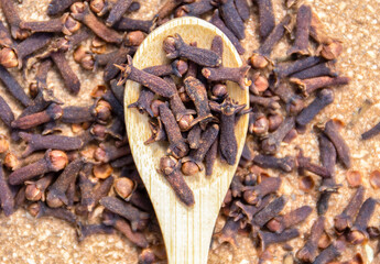 Dry clove spice on a wooden spoon close up. Spicy spice of cloves.  Dry spice cloves.