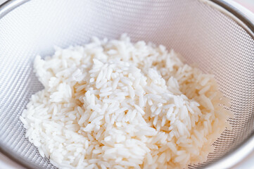 笊で水を切るタイ米のもち米