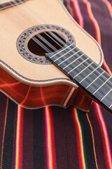 Obraz premium Traditional Andean instruments elegantly arranged on a striped textile. The Charango, Mandolin, and Bandolina are artfully crossed, highlighting their fine details and cultural significance.