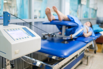 Mechanical traction or decompression tension on the spine, taking pressure off the joints and discs of the spine giving pain relief. Physical therapy technology machine with paint in the background.