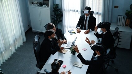 Top view of manager working on laptop and sending data analysis to business people by using VR glass headset while diverse team moving gesture while working together to planning idea. Directorate.