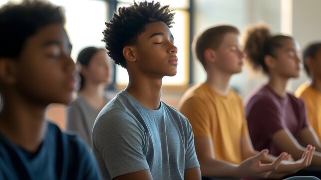 A diverse group of teenagers practicing mindfulness and meditation in a serene indoor setting. 