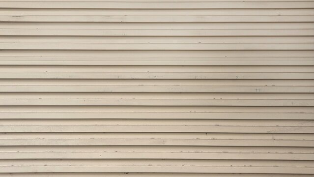 Old cream metal roller shutter door. Line pattern texture background. Aluminum doors. Old gray metal roller shutter door background texture.