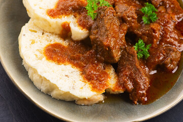 Beef goulash and dumplings (knedliky) on table