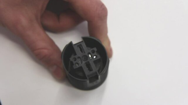 Close-up demonstration of connection ports in an E27 socket, detailed view of electrical component, wiring installation, DIY electrical work, hands-on tutorial