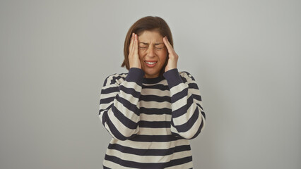 A middle-aged woman expresses headache against a white isolated background.