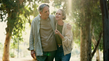 Old father and his daughter walking and talking in park