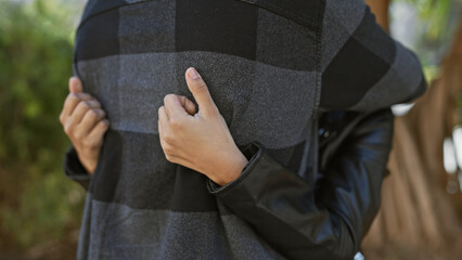 A woman embracing a man from behind on a sunlit urban street, signifying love and companionship.