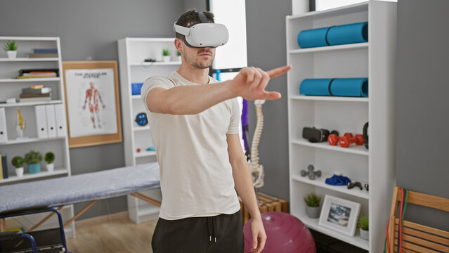 A young hispanic man wearing a vr headset in a modern physical therapy clinic