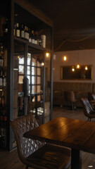 Cozy restaurant interior with wooden tables, leather chairs, wine bottles, warm lighting, and a relaxed atmosphere