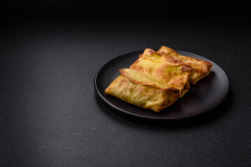 Homemade fried pancakes with filling on a ceramic plate