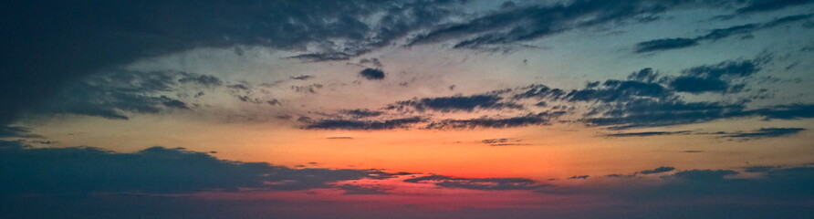 Obraz premium Panoramic sunset view over a rural landscape and plowed field.