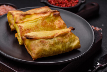 Homemade fried pancakes with filling on a ceramic plate