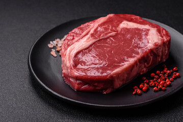 Fresh, raw beef steak with salt, spices and herbs