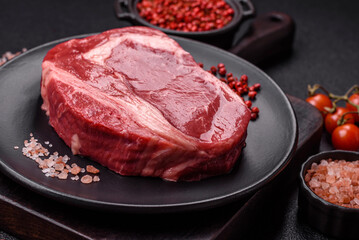 Fresh, raw beef steak with salt, spices and herbs