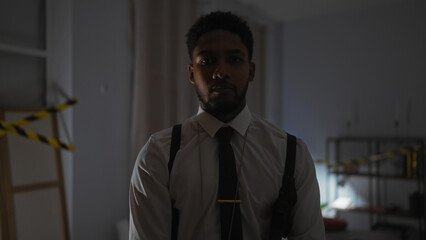 Handsome african american man in detective setting with crime tape indoors