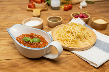Delicious food's special menu homemade preparing station spaghetti with minced meat top tomato sauce and basil shooting placing elements serving with chef table surround decorative spices. Postulate.