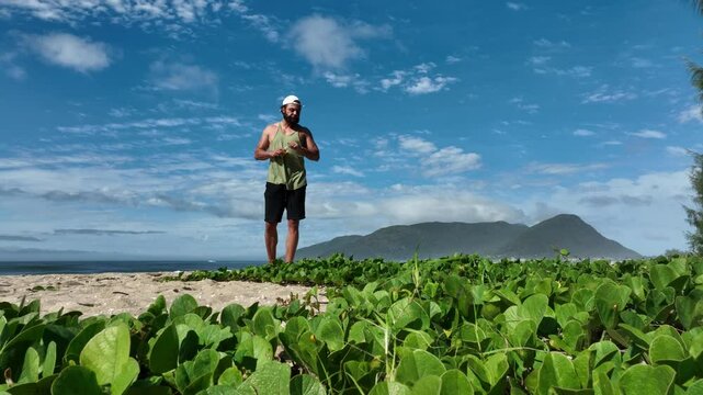 Man on a sunny day at the beach having a picnic, eating and drinking water. Outdoor concept.
