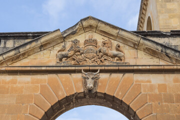Obraz premium Malta, between Senglea and Birgu, carving on Royal Navy Victualling Yard gate. British Royal Coat of Arms. And a cow's head.