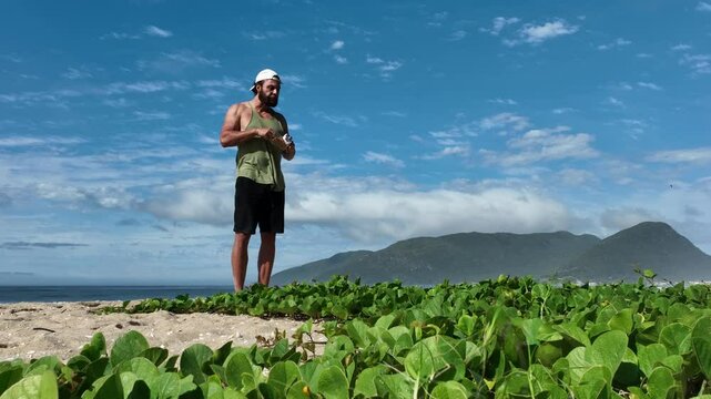 Man on a sunny day at the beach having a picnic, eating and drinking water. Outdoor concept.
