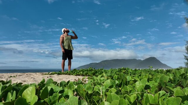 Man on a sunny day at the beach having a picnic, eating and drinking water. Outdoor concept.
