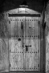 Old black and white door in dark concrete wall, empty abstract interior, square background texture