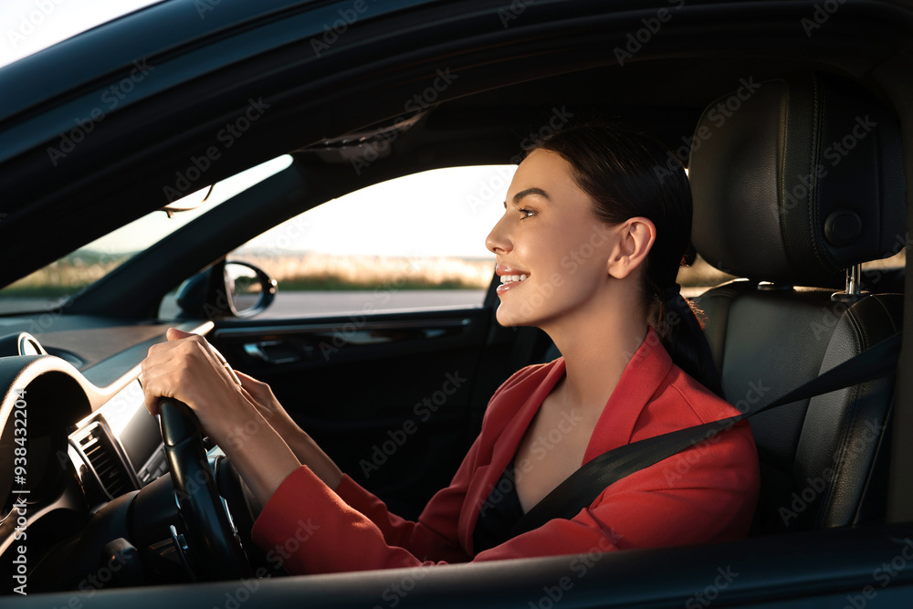 Wall mural smiling young woman with seatbelt driving car, view from outside