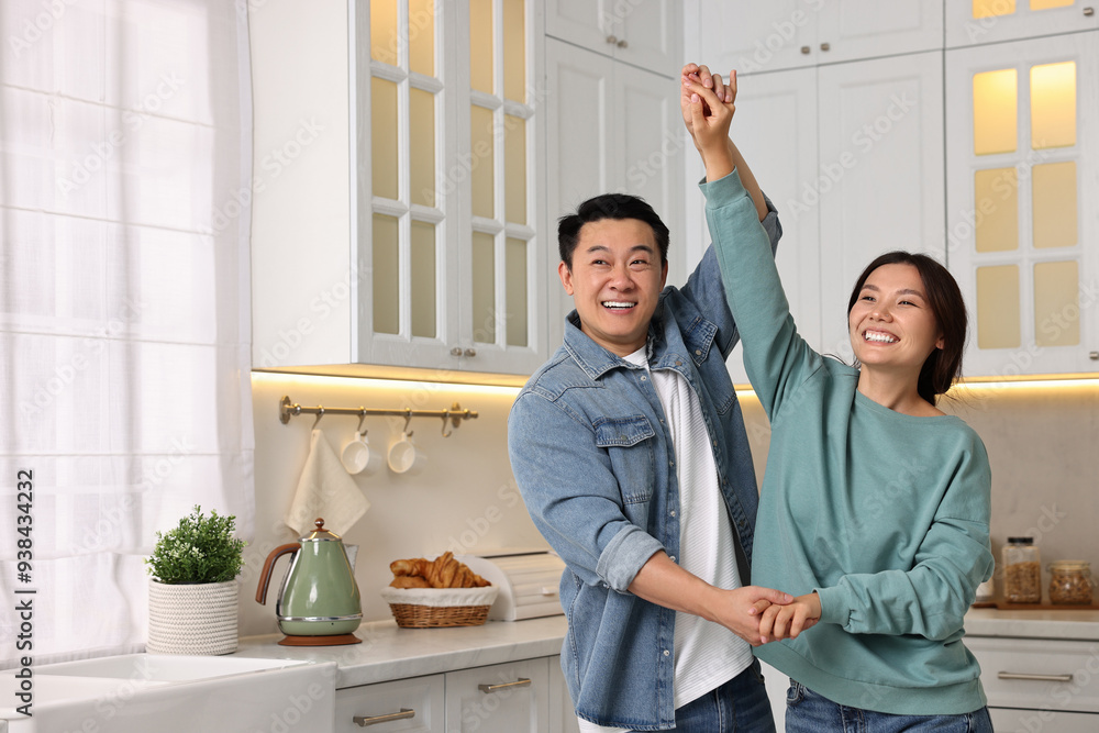 Wall mural happy lovely couple dancing together in kitchen