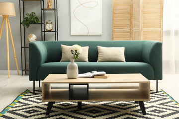 Comfortable sofa, coffee table and folding screen in stylish living room. Interior design