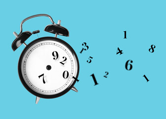 Numbers flying away from alarm clock on light blue background. Time related concepts
