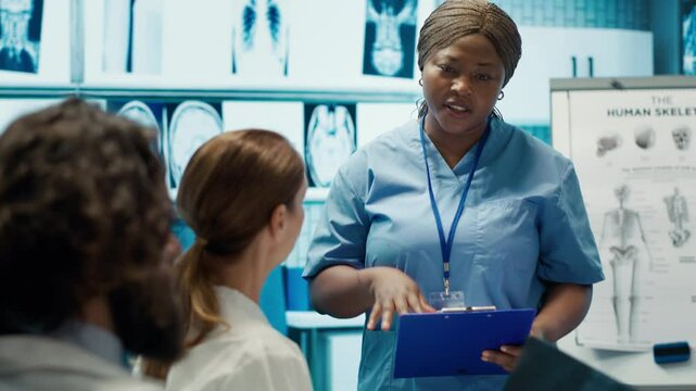 Medical team reviewing diagnostic x rays in a healthcare facility, focusing on disease prevention and early virus detection to provide treatment care. Licensed doctors consulting results. Camera A.