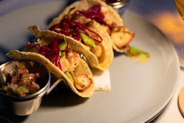 Close-Up of Grilled Octopus Tacos with Avocado and Pickled Onion  - Night Dining Scene, Vibrant Evening Food and Drink