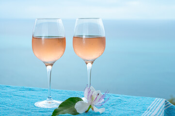 Summer time in Provence, two glasses of cold rose wine with blue sea view on background, French Riviera near Menton, south of France